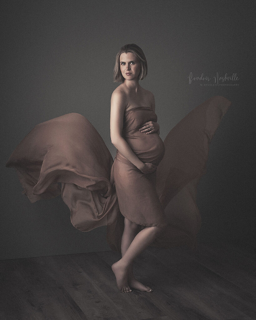 Flowy material tossed in the air for a beautiful maternity photo.